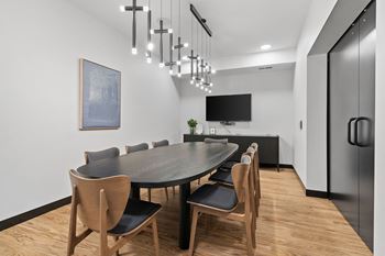 a dining room with a long table and chairs and a tv